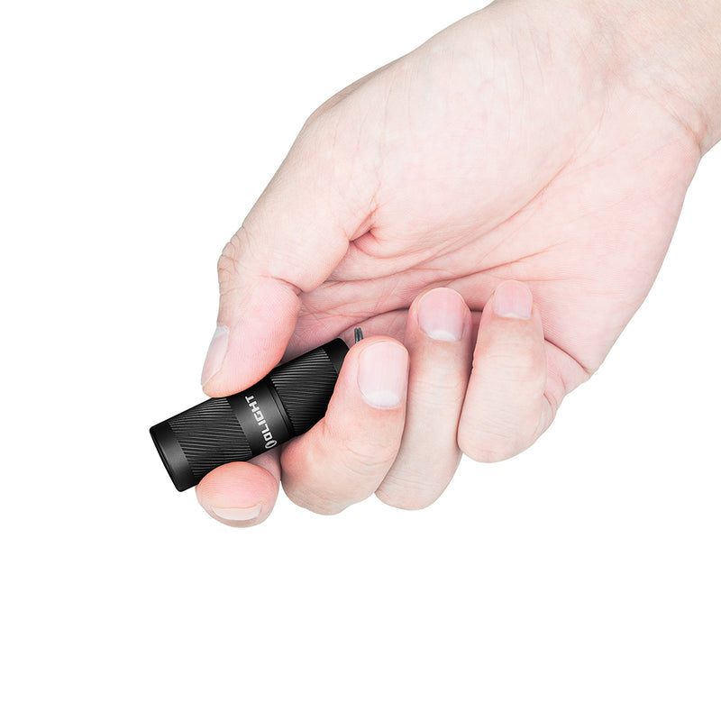 a hand holding the olight ir2 pro keychain flashlight