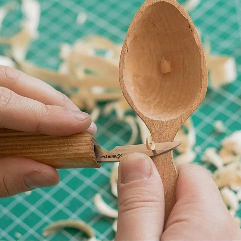 Detail knife carving a wooden spoon